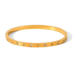 Macro detail of gold-plated stainless steel bangle with inlaid sparkling zircon stones