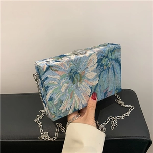 Detail of floral jacquard texture on rectangular box bag with silver chain and clasp