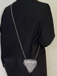 Detail of silver heart-shaped metal mesh crossbody bag with elegant chain strap