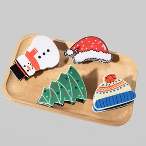 Christmas hair claw clips set with Santa hat, snowman, and tree on a wooden tray