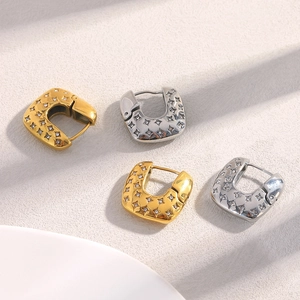 Detail of 18K gold and silver plated square hoop earrings with star pattern and zircons