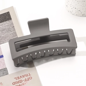 Macro shot of large matte grey rectangular hair claw clip for elegant hair styling
