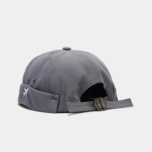 Détail du bonnet miki gris foncé montrant la broderie avion et la boucle en métal
