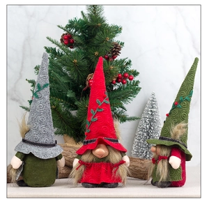 Close-up of three handmade Nordic Christmas gnomes with knit hats and faux fur beards