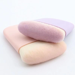 Lentil-shaped makeup powder brushes with purple and pink handles on white background