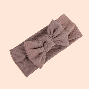 Detailed view of brown ribbed knit baby headband with a large decorative bow