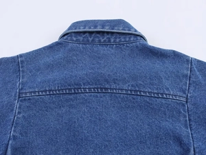 Detailansicht des Denim-Hemdkragens und der Nähte auf dem blauen Baumwollstoff