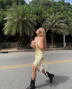 Pale yellow satin slip dress featuring elegant white lace trim and irregular hemline