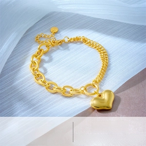 Detailed shot of vintage gold heart pendant with asymmetrical link and fine double chains