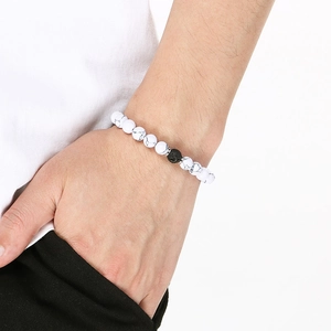 Close-up of white marble stones and black lava beads with silver spacers on a model's wrist
