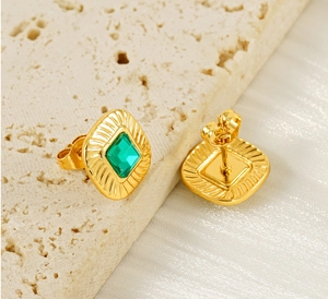 Detailed view of vintage gold square earrings with green zircon and butterfly back