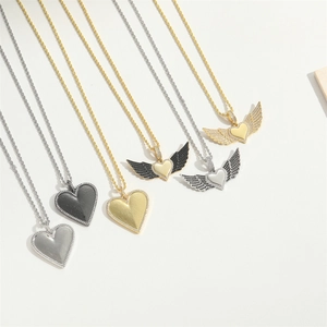 Luxe heart pendant necklaces in gold, silver, and black with twisted chains on white background
