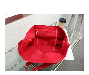 Interior view of red canvas tote bag showing spacious compartment and zippered inner pocket