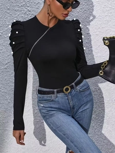 Elegant black long sleeve top with pearl puff sleeves and asymmetrical metal zipper detail