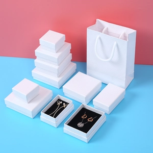 Detailed view of white litchi pattern jewelry gift boxes and matching paper bags