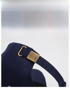 Détail de casquette bleu marine avec boucle réglable en bronze et gravure FARD précise