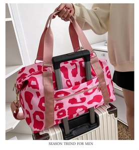 Pink leopard print travel bag with back trolley sleeve fixed on white luggage handle