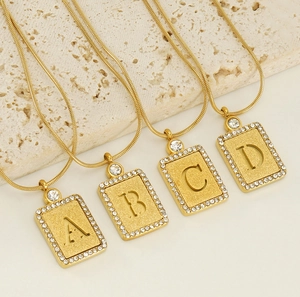 Vue détaillée des pendentifs lettres A-D plaqués or 18k avec diamants sur pierre naturelle