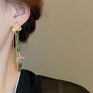 Detail of Chinese style bamboo joint tassel earrings with gold flower and green jade stones