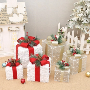 Detail of white flocked and translucent Christmas gift boxes with pine cones and ribbons