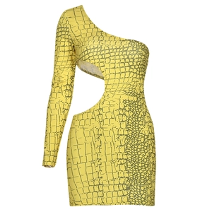 Detail der gelben Krokodilmuster-Textur und des Hohlraum-Ausschnitts am Mini-Bodycon-Kleid