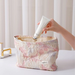 Floral embossed cosmetic bag with pink and white jacquard pattern and metal zipper closure