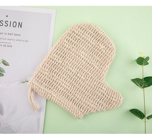 Detail of a heart-shaped linen bath glove with woven texture and a hanging rope