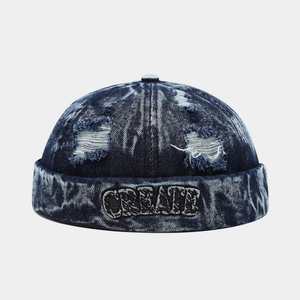 Close-up of CREATE embroidery and distressed denim details on a retro brimless docker hat