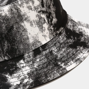 Close-up detail of black and white tie-dye bucket hat showing fabric texture and fine stitching