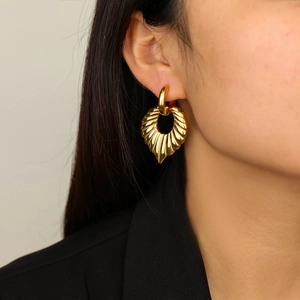 Chic gold-plated titanium steel heart earrings with textured fan pattern on a female model