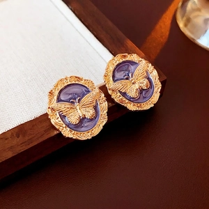 Vintage gold butterfly stud earrings with purple enamel inlay in a classic oval design