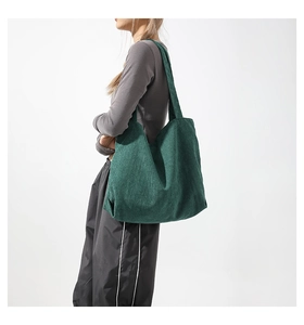Detailed texture of dark green corduroy tote bag showing fine vertical striped fabric