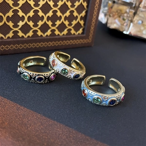 Detailed macro view of three gold vintage rings with colorful enamel and zircon stones