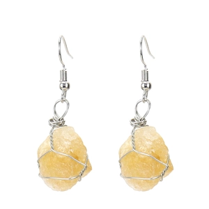 Detail of silver wire-wrapped raw yellow crystal earrings with natural stone textures