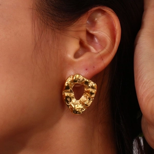 Irregular textured gold hoop earrings with lava aesthetic for women in minimalist style