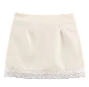 Detail of cream white silky mini skirt featuring elegant eyelash lace trim hem