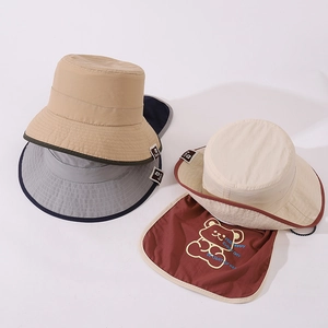 Close-up of baby sun hats with neck protection flaps and cute cartoon bear prints