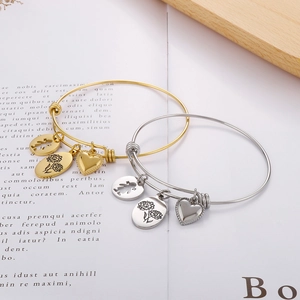 Detail of adjustable gold and silver bracelets with heart, flower, and silhouette charms