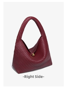 Detail of dark wine red woven crescent bag with iconic golden spherical metal clasp