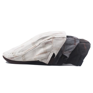 Detail of plaid cotton beret hats in cream, dark grey and coffee colors with fabric texture