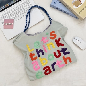 Detail of colorful chenille embroidery text on durable canvas tote bag surface