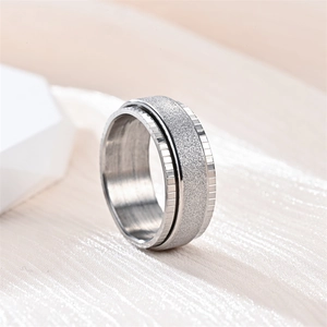 Close-up macro view of a silver rotating frosted titanium steel ring with textured grooves
