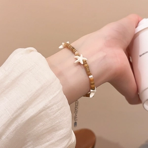 Detail of beaded sea star bracelet with brown resin discs on a model wrist