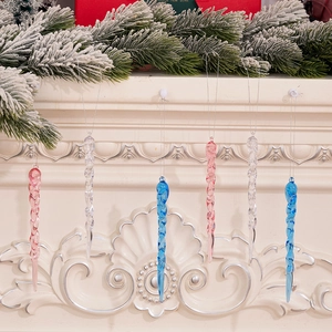 Detail of spiral acrylic icicle ornaments in pink and blue hanging from a festive mantle