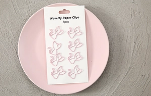 Detail view of 8 pink cat-shaped novelty paper clips on a pink plate for stationery use