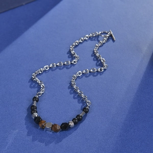 Tiger eye and matte stone beaded necklace with stainless steel OT buckle on blue surface