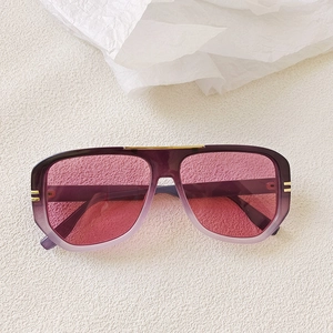Detail of oversized oval sunglasses with purple gradient frames and gold metal accents
