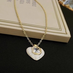 Macro detail of vintage heart pendant necklace with white enamel and square zircon