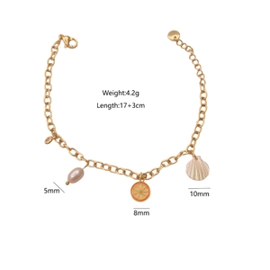 Golden bracelet with natural pearl, orange slice, and shell charms on white background