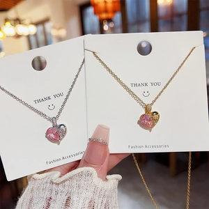 Vue détaillée des colliers en forme de cœur avec gemmes roses en finitions or et argent